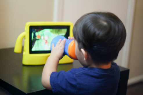 niño comiendo delante de una tablet