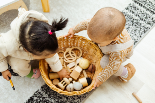 niños con un cesto de los tesoros de madera montessori
