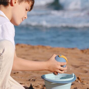 Niño jugando con el set de playa de juguetes biodegradables